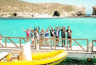 Gli studenti salutano dalla barca ferma nella Blue Lagoon a Comino