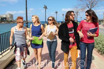 Gli studenti praticano inglese dopo le lezioni accanto a St Julians Bay, Malta