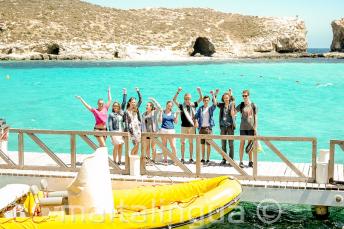 Gli studenti salutano dalla barca ferma nella Blue Lagoon a Comino