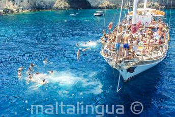 Gli studenti si tuffano dalla barca a Crystal Bay, Comino.