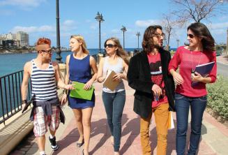 Gli studenti praticano inglese dopo le lezioni accanto a St Julians Bay, Malta