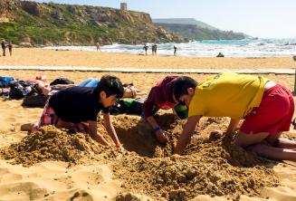 Gli animatori e i bambini giocano con la sabbia