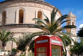 Una cabina telefonica rossa davanti alla chiesa di Mosta